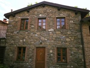 Corfino全景酒店的一座带窗户和门的石头建筑