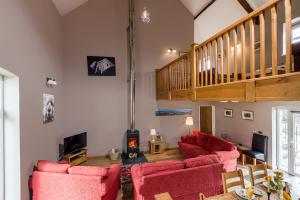 KidwellyKidwelly Farm Cottage的一间带红色椅子和楼梯的客厅