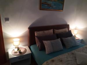 布德瓦安吉拉公寓酒店的一间卧室配有一张带枕头的床和两盏灯。