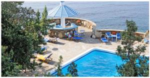 阿梅尼斯蒂斯Daidalos Hotel的享有带椅子和遮阳伞的游泳池的顶部景致
