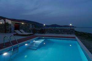 阿基奥斯基利考斯ANEFANTI VILLAS的享有水景的游泳池(晚上)