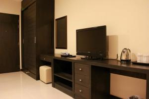 曼谷拉查达雅庭13公寓式酒店 的客厅配有书桌上的电视