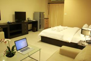 曼谷拉查达雅庭13公寓式酒店 的配有床和笔记本电脑桌的酒店客房