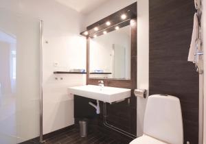 恩雪平孔帕森酒店的一间带水槽、卫生间和镜子的浴室