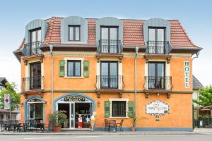 鲁斯特Hotel Casa Rustica - Eintrittskarten für den Europapark erhalten Sie garantiert über uns!的一座橙色的建筑,设有窗户和阳台,位于街道上