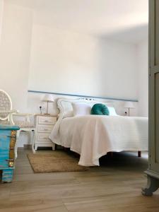 利洛Apartamentos Turísticos Casa Dina的卧室配有白色的床和梳妆台。