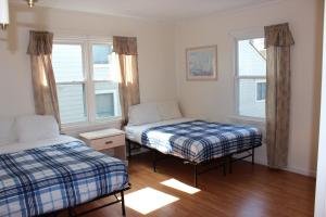 大洋城Blue Haven Apartments的一间卧室设有两张床和两个窗户。