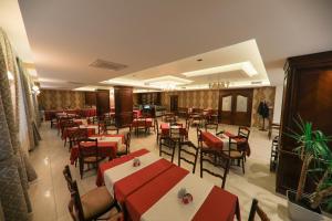 普里兹伦Hotel Kacinari的餐厅设有红色和白色的桌椅