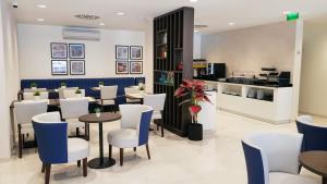 波尔图Porto City Hotel的餐厅设有白色和蓝色的椅子和桌子