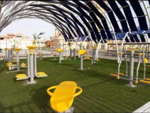沙姆沙伊赫Chalets in Porto Sharm - Families Only AN的草地上带黄色椅子的游乐场
