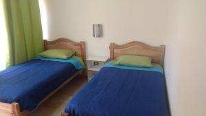 卡拉马Hotel Doña Esperanza的两张睡床彼此相邻,位于一个房间里