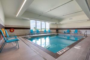 纳帕尼Comfort Inn & Suites的大楼内带蓝色椅子的大型游泳池
