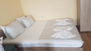 戈采代尔切夫Апартамент за нощувки的一张带白色床单和枕头的床