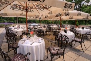 锡尔沃斯瓦里德拉康特萨城堡酒店的一间设有白色桌椅和遮阳伞的餐厅