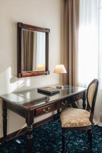伊尔库茨克太阳酒店的一张带镜子的桌子、一盏灯和一把椅子