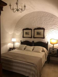 内图诺Le Stanze del Borgo的一间卧室配有一张大床和两盏灯。