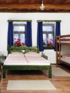 BátorNevenincs Vendégház的一间卧室配有蓝色窗帘的绿色床