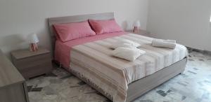 曼杜里亚Felline House的一间卧室配有一张大床,铺有粉色和白色的床单。