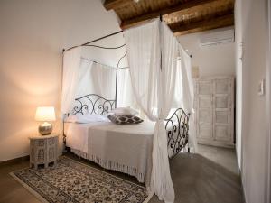 锡拉库扎Ortigia Boutique Palace的卧室配有带窗帘的白色天蓬床
