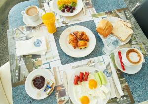 苏恰瓦MyContinental Suceava的餐桌上摆放着早餐食品和咖啡盘
