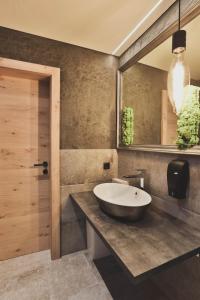 皮茨河谷圣莱昂哈德Alpine Resort Sportalm的一间带大水槽和镜子的浴室