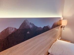 格拉斯布伦林登霍夫膳食公寓酒店的卧室的墙上挂有山壁画