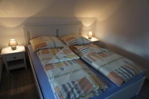 奥伊宾Ferienhaus Lusatia am Töpfer的一间卧室设有两张床和两张台灯。