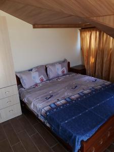 An NakhlahKoura Nahla Apartment的一间卧室配有一张带蓝色棉被的床