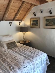 埃姆斯特The Barn的一间卧室配有一张带灯和墙上照片的床。
