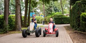 埃德TopParken – Recreatiepark ’t Gelloo的两个男人在公园里骑玩具车