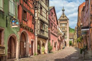 利克维ADRIHOF à Riquewihr, Cour de l'Abbaye d'Autrey的一座带钟楼老城区的小巷