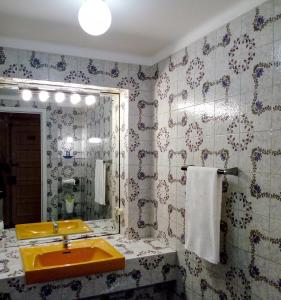 里斯本Famille au Cœur de Lisbonne的浴室设有黄色水槽和镜子