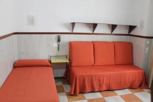 科尔多瓦唐宝拉酒店的客房设有两张橙色的床和电话