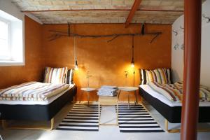 SundstrupPorshus Ferielejlighed的橙色墙壁客房的两张床