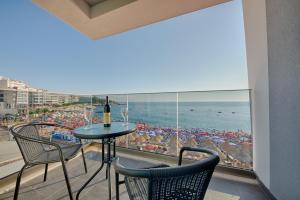 多布拉沃达Hotel Obala的阳台配有桌椅,享有海滩美景。