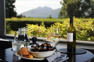 格伦科阿可仑巴拉楚利什酒店的一张桌子,上面放着一盘食物和一瓶葡萄酒