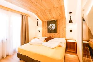 佩尔卡Naturhotel Miraval的一间卧室设有一张木天花板床。