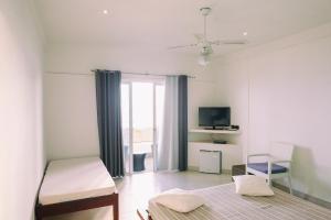贝岛Etoile Blanche的白色的客房配有床和电视。