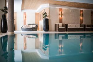 索尔达Hotel Lärchenhof的一间带游泳池和沙发的客厅
