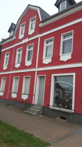 哈尔伯Ferienwohnung zum Schuster的一座红色的建筑,里面装着商店