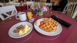 布兰森维多利亚大酒店的粉红色的桌子,上面有华夫饼和早餐食品