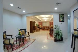 迪拜德尔拉套房豪华酒店的一间带椅子的客厅和一间餐厅
