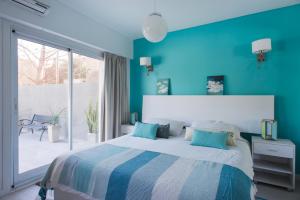 布宜诺斯艾利斯Soho Point Central的蓝色的卧室设有床和大窗户