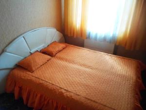 OkhtyrkaДом的一间卧室配有一张带橙色床罩的床和窗户。