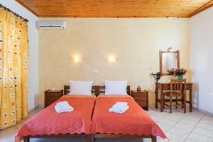 利迈纳里亚Konstantinos Beach 2的一间卧室配有两张带红色床单和镜子的床