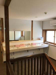 草津Oyado Zen的一间带水槽和大镜子的浴室
