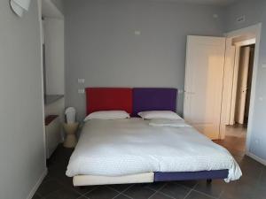 奥尔塔圣朱利奥Lake view rooms and flats Casa Sul Lago的一间卧室配有一张红色和紫色床头板的床