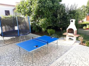 瓦图拉Kuća za odmor - apartman Vito的乒乓球桌和院子内的烧烤架