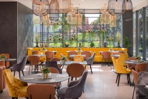 斯普利特Sia Split Hotel的餐厅设有桌椅和大窗户。