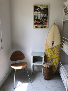 索尔特奥瑟戈尔Surfhostel Hossegor的一间设有冲浪板、椅子和桌子的房间